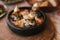 Close-up dish with mushrooms and white sauce in bowl on wooden stand. Traditional Turkish food.