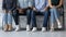 Close up diverse candidates sitting in row, waiting for job interview