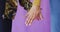 Close up of diverse couple holding hands on purple background