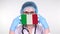 Close-up. Doctor in glasses, blue medical cap, gloves holds in hands medical mask with Italy flag. Physicians care