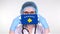 Close-up. Doctor in glasses, blue medical cap, gloves holds in hands medical mask with Kosovo flag. Physicians care