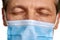 Close up doctor in mask closed eyes.