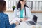 Close up of a doctor and patient sitting at the desk while physician pointing into laptop computer. Medicine and heal