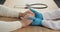 Close-up of doctor's hands in blue latex gloves hold male palms of caucasian man lie on table near stethoscope, symbol