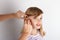 Close up of a Doctor`s hands fitting a hearing aid for a young girl