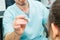 Close up doctor testing reflexes of the eye of young woman using a lamp in medical clinic. Neurological physical examination. Sele