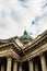 Close-up of the dome of the Kazan Cathedral with a golden cross part of a wall with columns and a frieze with windows, porticoes