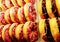 Close up donuts with chocolate frosted and pink glazed on shelf for sale.