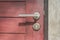 Close up door handle on closed brown wooden door.