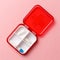 Close-up dose pill box with medical pills on pink background. Top view. Flat lay. Copy space