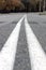 Close-up of double white continuous lines on empty asphalted road.