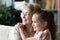 Close up dreamy smiling mature woman and granddaughter hugging