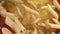 Close-up of dry raw pasta penne flying diagonally on a yellow ochre background