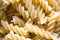 A close up of dry uncooked Fusilli pasta.