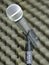 Close-up of a dynamic vocal microphone. Blurred background of acoustic foam.