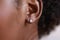 Close up of ear wearing shiny diamond earrings