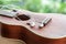 close-up of earphone with ukulele guitar on wooden table in the