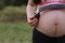 Close-up of Eastern Asian Chinese pregnant woman\'s belly, earphones on belly, antenatal training fetal education baby family