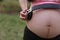 Close-up of Eastern Asian Chinese pregnant woman\'s belly, earphones on belly, antenatal training fetal education baby family