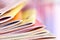 Close up edge of colorful magazine stacking with blurry bookshe