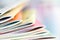 Close up edge of colorful magazine stacking with blurry bookshe