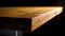 Close-up of edge of wooden table on dark background. Stock footage. Beautiful smooth edge of brown wooden table lit by