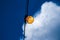 Close up of an Edison-style filament on a light bulb against a cloudy sky. Energy crisis