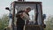 Close up elderly male farmer pouring water from canister into agricultural tractor on his farm