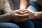 Close up of elderly mom and adult daughter hold hands