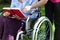 Close-up of an elderly woman in a wheelchair reading a book