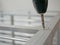 Close up of an electric screwdriver tightening a screw to assemble an aluminum storage shelves