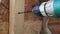 Close-up of an electric screwdriver tightens a screw.