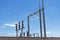 Close-up of electrical substation showing wires, ceramic insulators and birds nesting beneath them