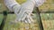 Close-up of elegant female hands in white gloves show gold beautiful rings in shop behind counter with jewelry