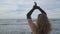 close up elegant young woman in black dress and long gloves dancing on beach. Vacation, freedom, enjoy concept