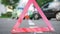 Close-up of an emergency sign against the background of arguing people at the colliding cars. Waiting for the police at