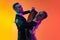 Close-up emotive dancing couple, beautiful man and woman dancing waltz isolated over gradient orange pink background in