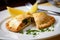 Close-up of an empanada with a delicious seafood filling, garnished with a slice of lemon and a sprig of parsley