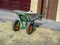 Close-up empty clean construction wheelbarrow on a sunny summer day outdoors. Work tool. Newly laid granite pavers sprinkled with