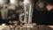 A close-up of an empty glass cup for latte standing on a bar counter with some coffee beans on it