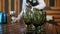 Close up empty green glass goblets in restaurant interior and waitress on background serving table. Set vintage