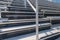 Close-Up of empty metal stadium bleacher seats along aisle with steps and railing.