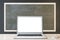 Close up of empty white laptop and mouse on chalkboard background, Education, seminar, workshop and mockup concept.