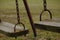 A close up of the ends of two swings