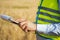 Close-up of an engineer\'s hands holding a folder in a wheat field in summer