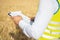 Close-up of an engineer\'s hands holding a folder in a wheat field in summer