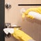 Close up entrance door knob being cleaned with sanitizer spray by female hands in yellow latex gloves, selective focus