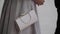 Close-up of evening handbag hanging from shoulder of woman in dress