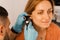 Close-up examination of womans ear with otoscope. Otoscopy. Visit to ENT doctor and consultation.