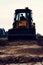 A close-up excavator loads soil into the bucket for further road installation